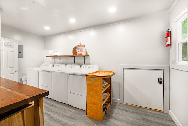 washroom with washer and clothes dryer, light hardwood / wood-style floors, ornamental molding, and electric panel