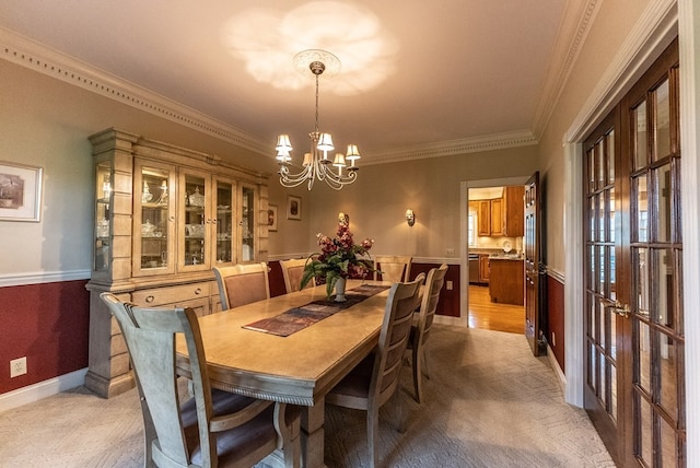 dining space featuring light hardwood / wood-style flooring, ornamental molding, and a chandelier