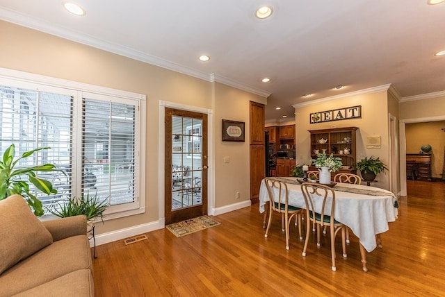 dining space featuring crown molding and wood-type flooring