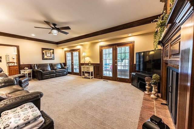 carpeted living room featuring crown molding, french doors, a fireplace, and ceiling fan