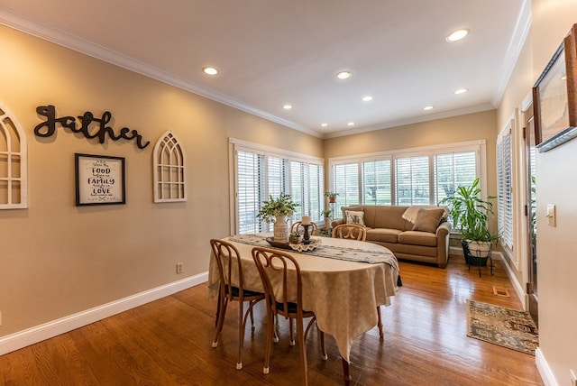 dining space featuring wood-type flooring and ornamental molding