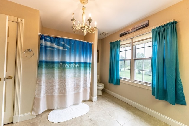 bathroom with tile patterned flooring, toilet, and an inviting chandelier