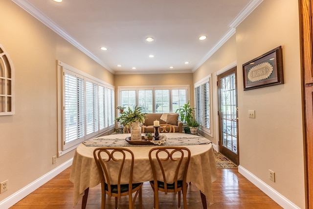 dining area with light hardwood / wood-style floors and ornamental molding