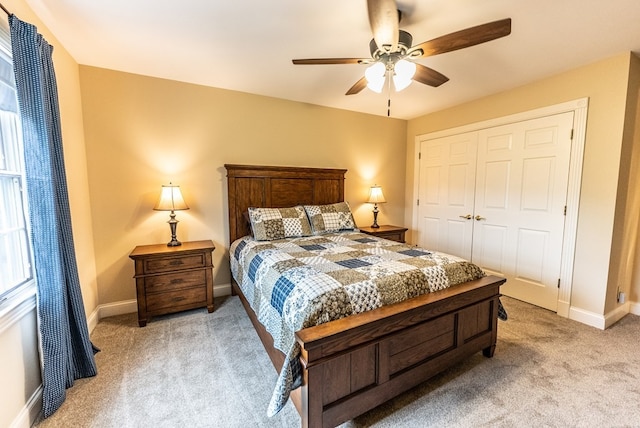 carpeted bedroom with ceiling fan and a closet