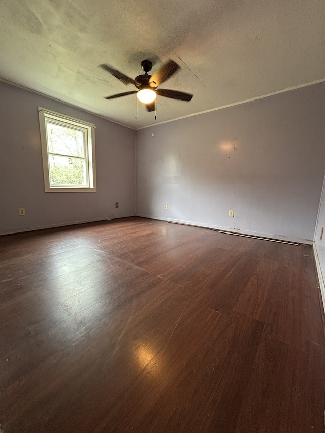 empty room featuring a textured ceiling, ceiling fan, and dark wood-type flooring