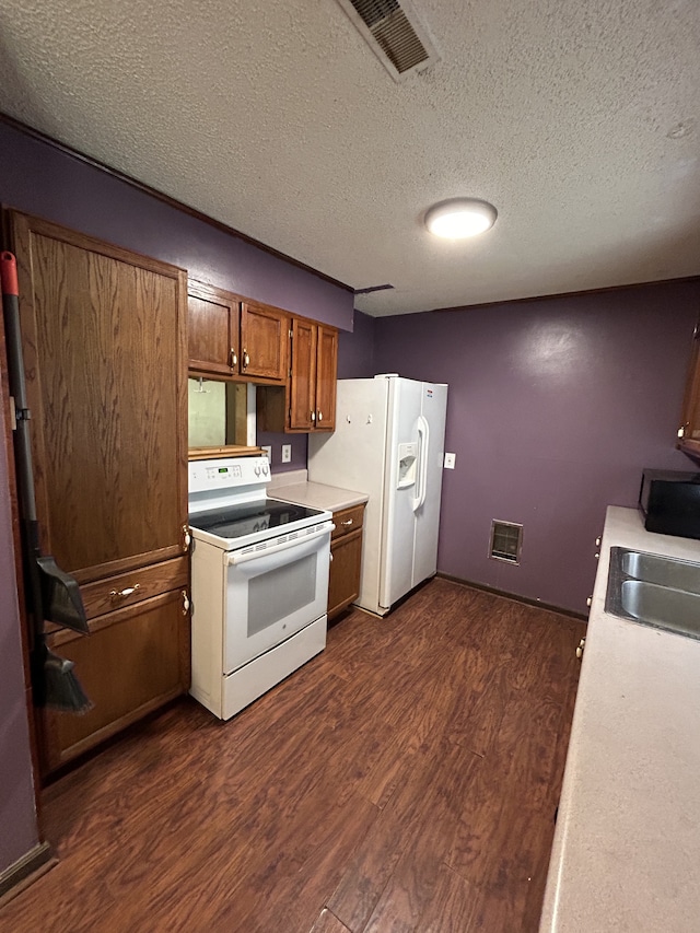 kitchen featuring sink, dark hardwood / wood-style flooring, white appliances, and a textured ceiling