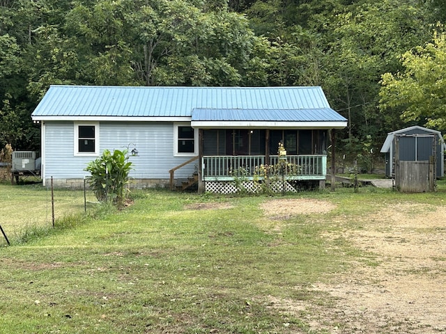 back of house featuring a yard and a storage unit