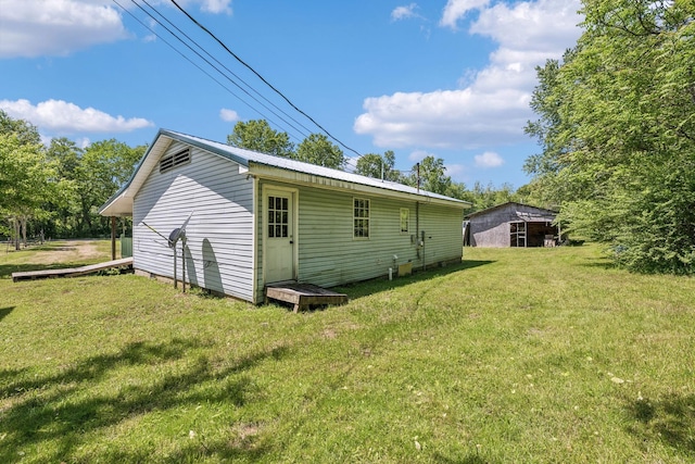 163 Longbranch Rd, Hohenwald, TN 38462 - back of property featuring a lawn, an outdoor structure, and metal roof
