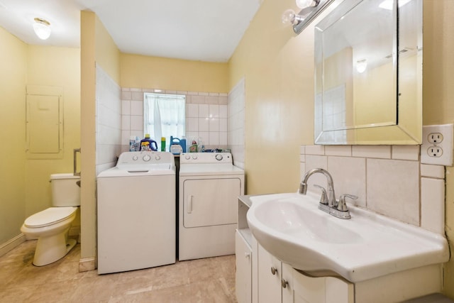 163 Longbranch Rd, Hohenwald, TN 38462 - bathroom with washing machine and dryer, toilet, vanity, tasteful backsplash, and tile walls