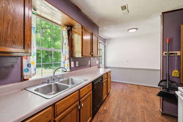 163 Longbranch Rd, Hohenwald, TN 38462 - kitchen with black dishwasher, a sink, a textured ceiling, dark wood-style flooring, and wainscoting