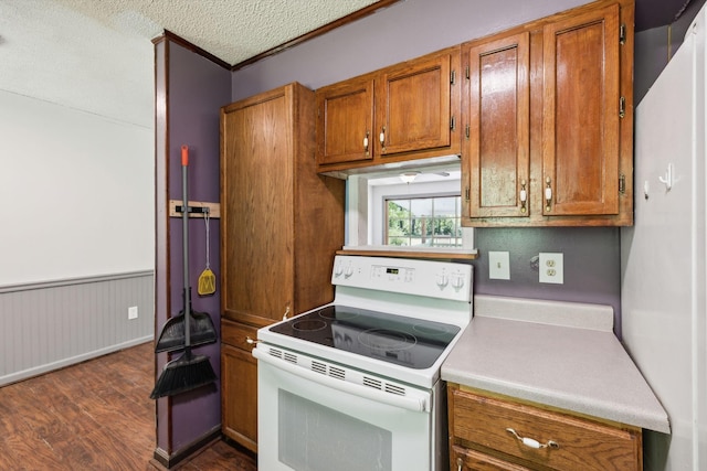163 Longbranch Rd, Hohenwald, TN 38462 - kitchen with white electric stove, brown cabinetry, dark wood-style floors, light countertops, and wainscoting