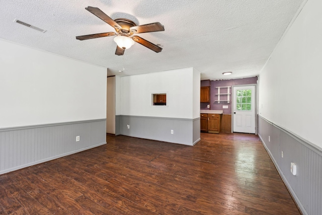 163 Longbranch Rd, Hohenwald, TN 38462 - unfurnished living room featuring dark wood finished floors, ceiling fan, a textured ceiling, and a wainscoted wall