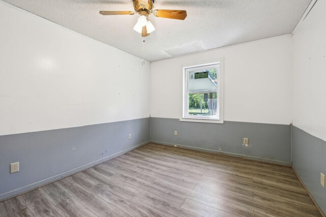 163 Longbranch Rd, Hohenwald, TN 38462 - empty room with wood finished floors, a textured ceiling, a ceiling fan, and baseboards