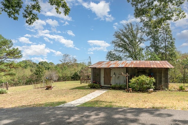 view of front of home featuring a front lawn and an outdoor structure