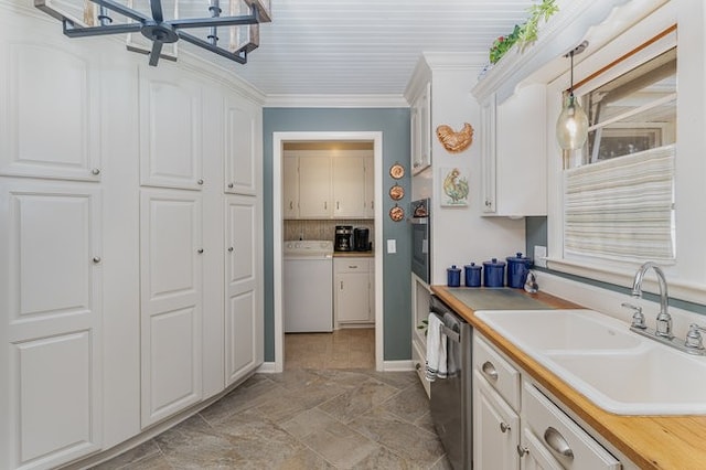 kitchen featuring washer / clothes dryer, appliances with stainless steel finishes, white cabinetry, and sink