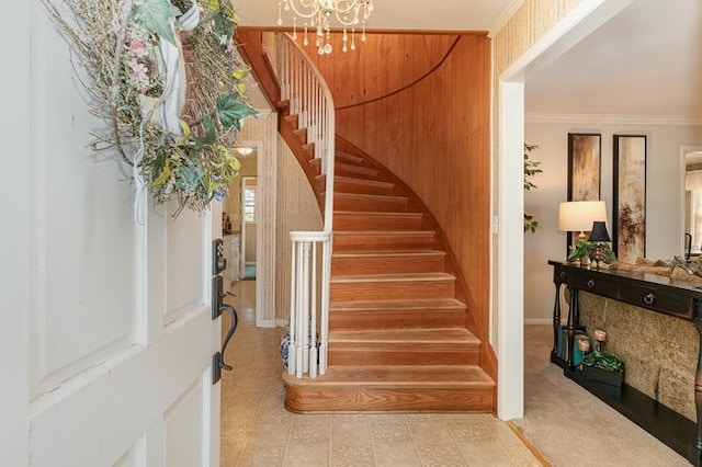 entryway with an inviting chandelier and crown molding