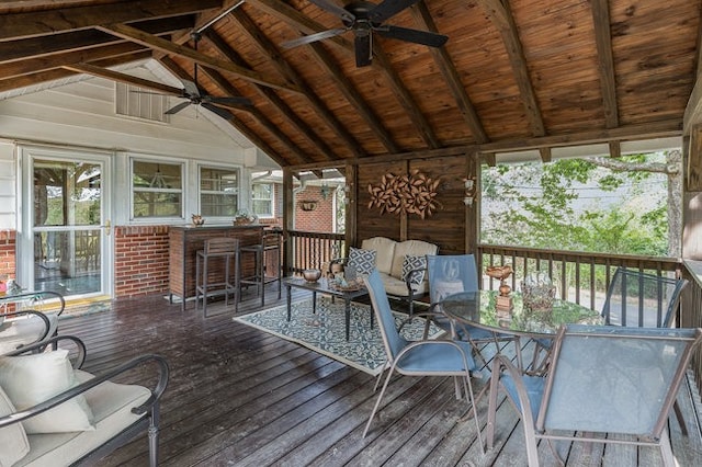 unfurnished sunroom featuring lofted ceiling with beams, a wealth of natural light, ceiling fan, and wood ceiling