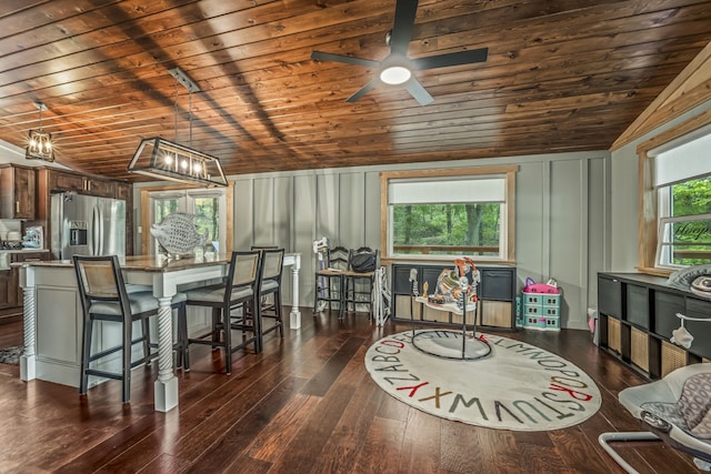 dining space with ceiling fan, lofted ceiling, dark wood-type flooring, and wooden ceiling