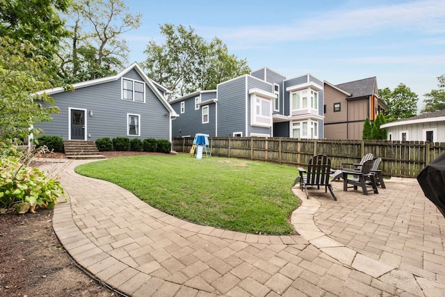 back of property with a yard, a patio area, and a playground