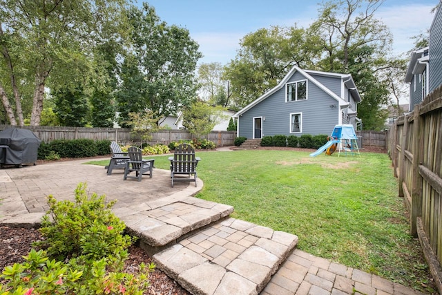 view of yard featuring a playground and a patio area