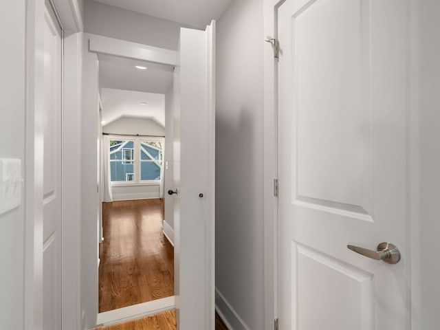 hallway featuring hardwood / wood-style flooring and vaulted ceiling