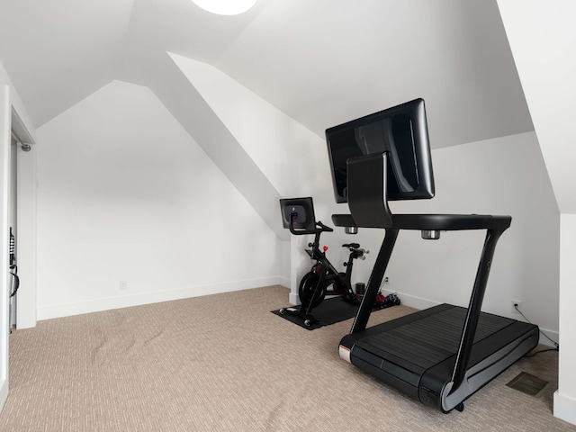 workout area featuring light colored carpet and vaulted ceiling