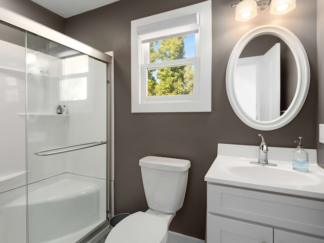 bathroom with vanity, a shower with shower door, and toilet