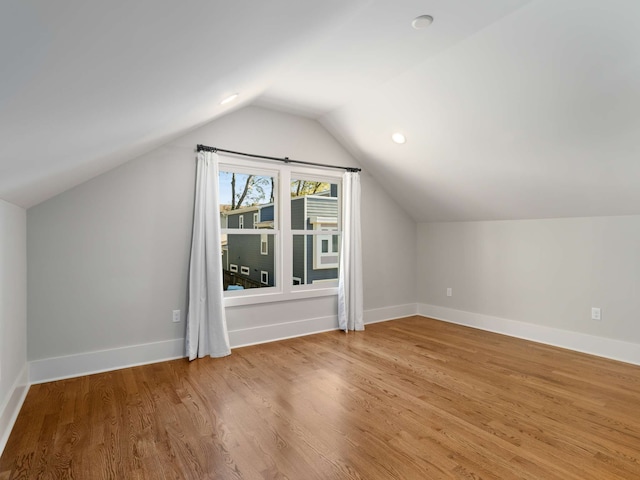 additional living space with vaulted ceiling and hardwood / wood-style floors