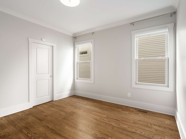 unfurnished room with ornamental molding and dark hardwood / wood-style floors