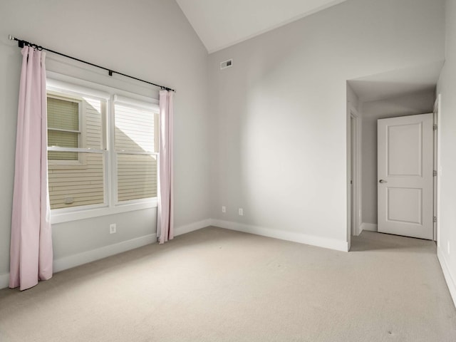 spare room with vaulted ceiling and light carpet