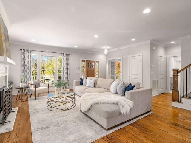 living room featuring crown molding and light hardwood / wood-style floors