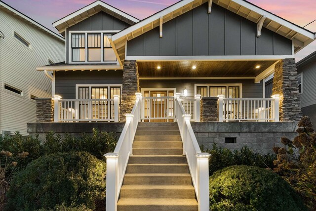2310 Vaulx Ln, Nashville, TN 37204 - view of front of house featuring covered porch, stone siding, board and batten siding, and stairs