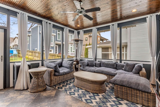 sunroom featuring ceiling fan and wood ceiling