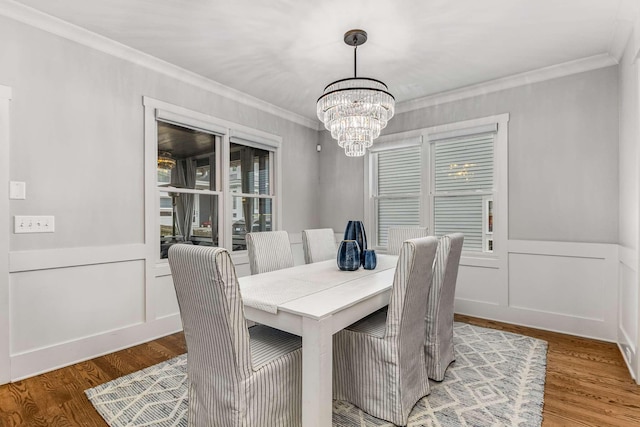 dining room with hardwood / wood-style floors, a notable chandelier, and ornamental molding