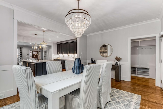 dining room featuring crown molding, a chandelier, and hardwood / wood-style floors