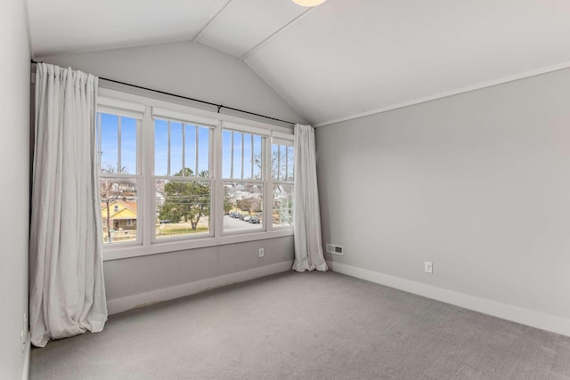 carpeted spare room with lofted ceiling