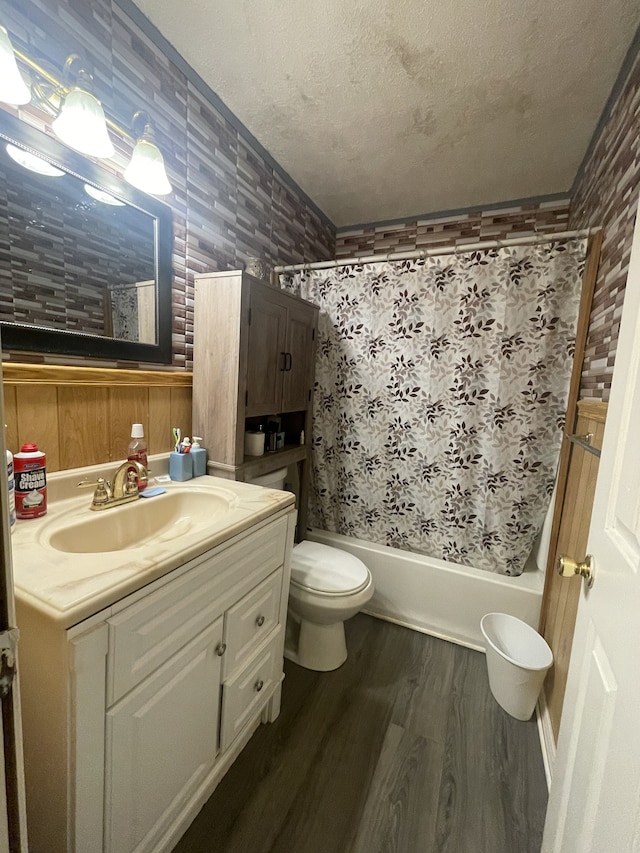 full bathroom featuring a textured ceiling, vanity, shower / tub combo, hardwood / wood-style floors, and toilet