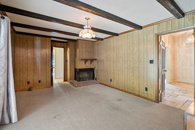 unfurnished living room featuring wooden walls, beam ceiling, light carpet, and a brick fireplace