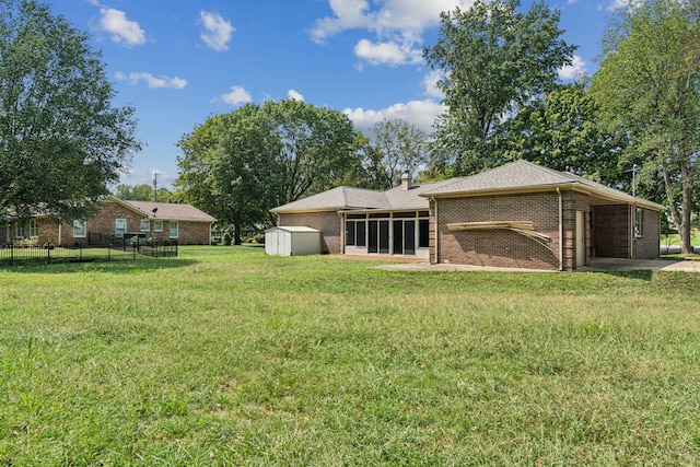 exterior space with a storage shed, a sunroom, and a yard