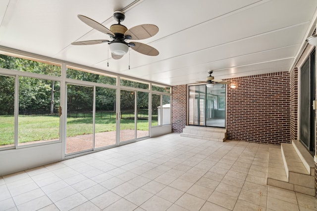 unfurnished sunroom featuring ceiling fan