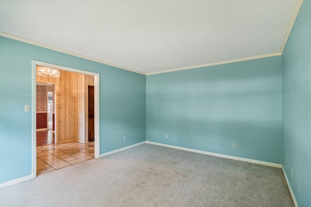 carpeted spare room with crown molding, a textured ceiling, and a notable chandelier