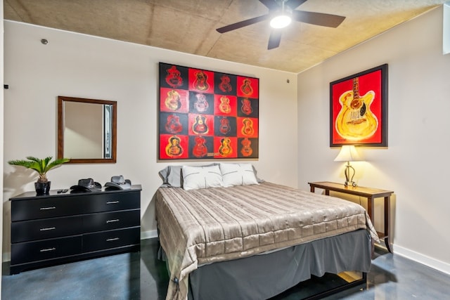 bedroom with ceiling fan, concrete floors, and baseboards