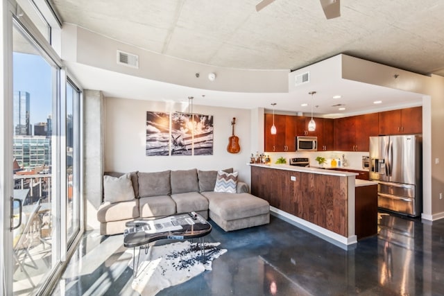 living area with baseboards, visible vents, concrete floors, and ceiling fan