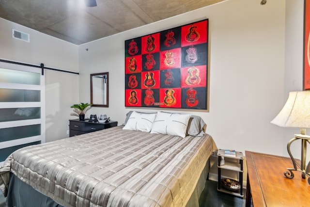 bedroom with a barn door and visible vents