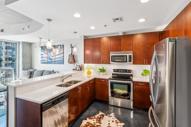 kitchen featuring appliances with stainless steel finishes, sink, kitchen peninsula, and hanging light fixtures