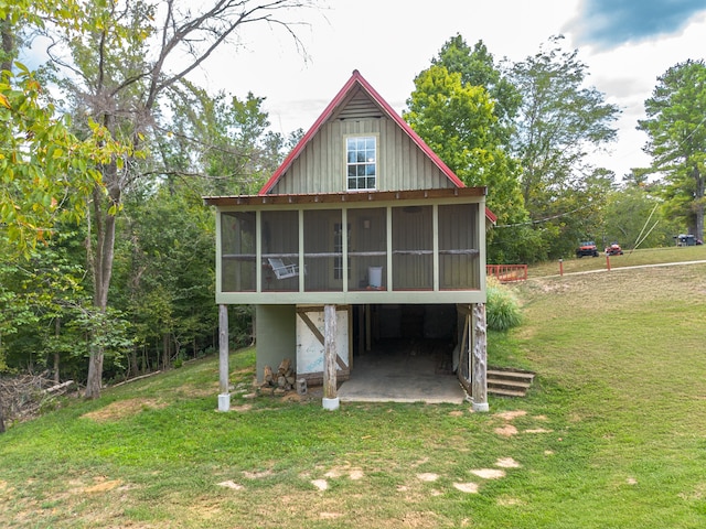 rear view of property with a yard and a sunroom