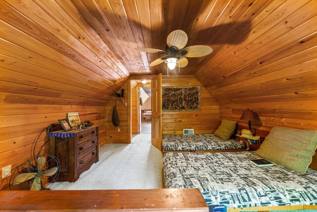 carpeted bedroom featuring wood ceiling, vaulted ceiling, wooden walls, and ceiling fan