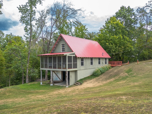 rear view of property with a yard and a sunroom