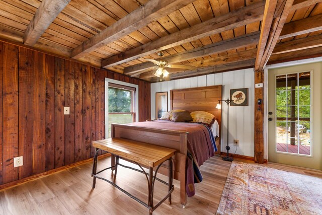 bedroom featuring light hardwood / wood-style flooring, wood walls, beamed ceiling, and wooden ceiling