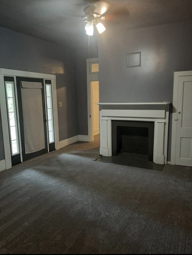 unfurnished living room with dark carpet and ceiling fan